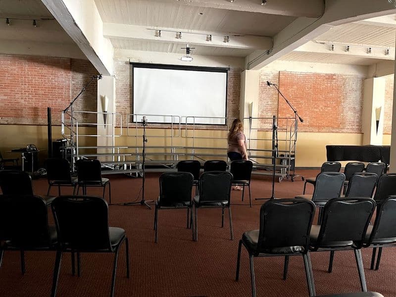 Main hall set for a screening with projector screen and stage risers