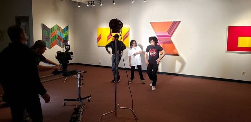 Film crew shooting dancers in the exhibit gallery