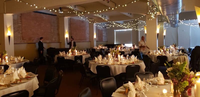 Banquet tables under string lights set for an evening reception